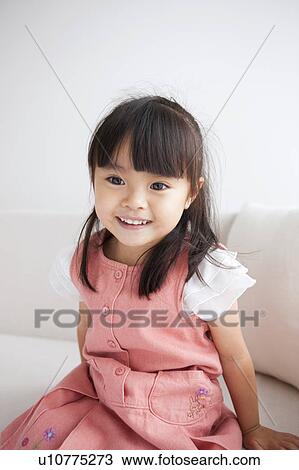 Stock Image - Girl sitting on sofa. Fotosearch
