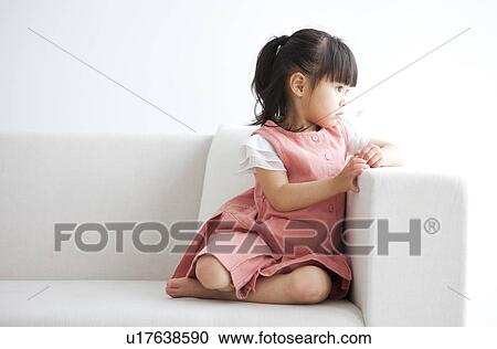 Girl sitting on sofa View Large Photo Image Stock Image - Girl sitting on sofa. Fotosearch