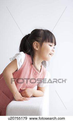 Girl sitting on sofa View Large Photo Image Stock Photo - Girl sitting on sofa. Fotosearch