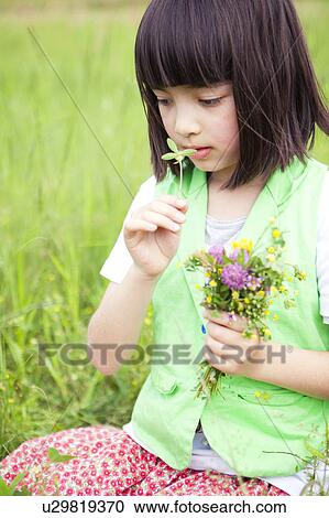 Stock Image - Girl Smelling Flowers. Fotosearch