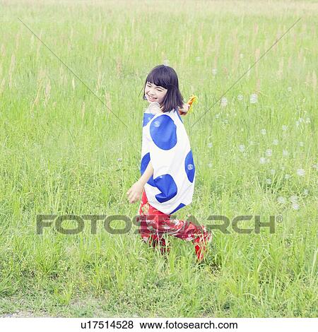 Stock Photo - Girl with Bubble Wand Walking in Field. Fotosearch