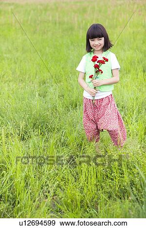 Stock Photo - Girl with Bunch of Flowers in Field. Fotosearch