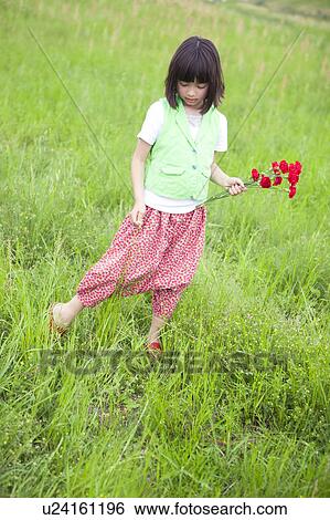 Stock Photograph - Girl with Bunch of Flowers in Field. Fotosearch