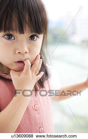 Girl with finger in mouth View Large Photo Image Stock Photo - Girl with finger in mouth. Fotosearch