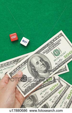 Hand Holding 100 Dollar Bills, Two Dice Spelling Out USD and Buy View Large Photo Image Stock Photograph - Hand Holding 100 Dollar Bills, Two Dice Spelling Out USD and Buy. Fotosearch