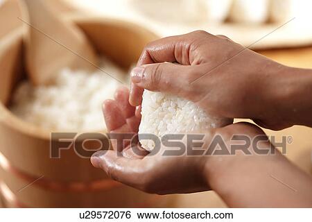 Stock Photograph - Hands making a rice ball. Fotosearch