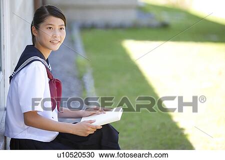 Stock Image - Junior High School girl holding a book. Fotosearch