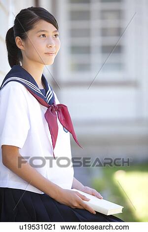 Stock Image - Junior High School girl holding a book. Fotosearch