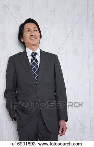 Mature businessman leaning on wall View Large Photo Image Stock Image - Mature businessman leaning on wall. Fotosearch