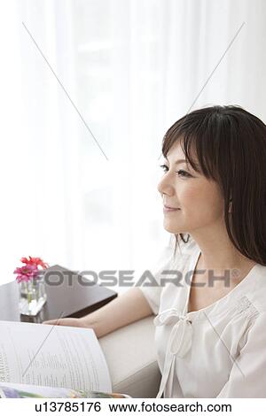 Stock Photograph - Mid Adult Reading Magazine. Fotosearch