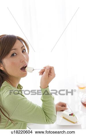 Picture - Mid Adult Woman Eating Cake. Fotosearch