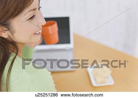 Mid Adult Woman Having Tea In Front Of Laptop View Large Photo Image Stock Photograph - Mid Adult Woman Having Tea In Front Of Laptop. Fotosearch