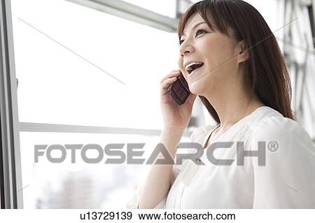 Mid Adult Woman on Phone and Looking Through Window View Large Photo Image Stock Photo - Mid Adult Woman on Phone and Looking Through Window. Fotosearch