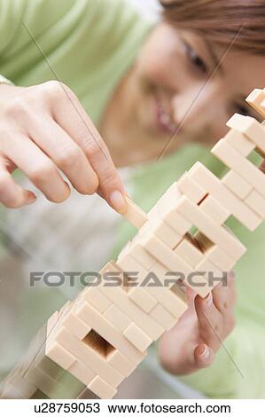 Stock Image - Mid Adult Woman Playing Jenga. Fotosearch