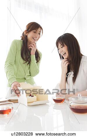 Stock Photo - Mid Adult Women Having Cake and Tea. Fotosearch