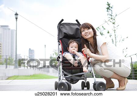 Stock Image - Mother and Baby Boy in Buggy. Fotosearch
