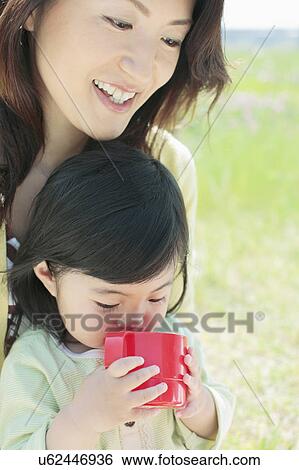 Stock Photograph - Mother and Daughter, Daughter Drinking. Fotosearch