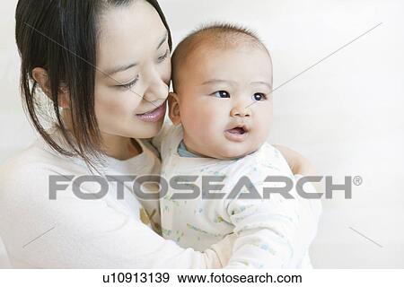 Stock Photo - Mother carrying a baby. Fotosearch
