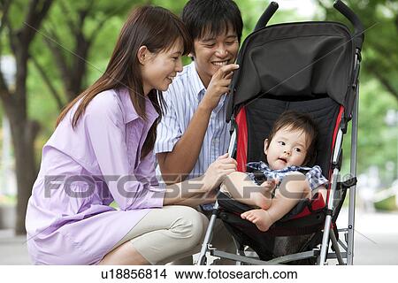 Parents Crouching Beside Baby Boy in Buggy View Large Photo Image Picture - Parents Crouching Beside Baby Boy in Buggy. Fotosearch