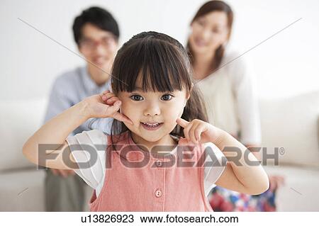 Portrait of a girl and parents sitting on sofa View Large Photo Image Stock Image - Portrait of a girl and parents sitting on sofa. Fotosearch