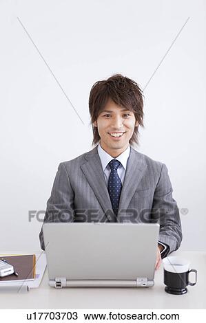 Stock Image - Portrait of businessman using laptop. Fotosearch