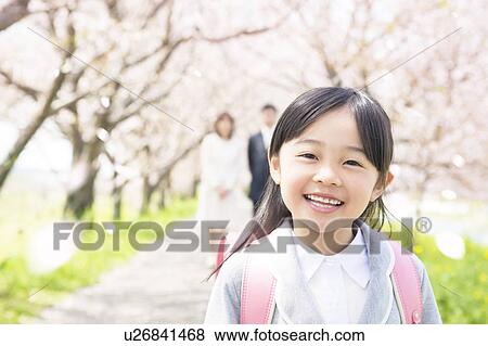 Portrait of girl with parents in background View Large Photo Image Stock Photo - Portrait of girl with parents in background. Fotosearch