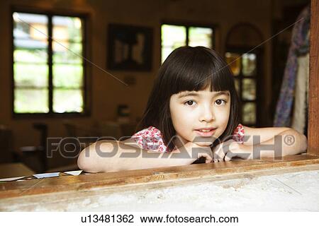 Stock Image - Portrait of Young Girl at Window. Fotosearch