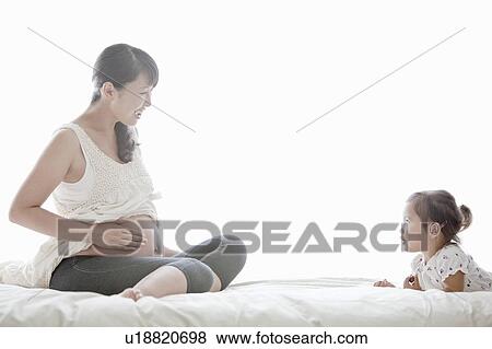 Stock Photo - Pregnant Mother and Her Young Daughter. Fotosearch