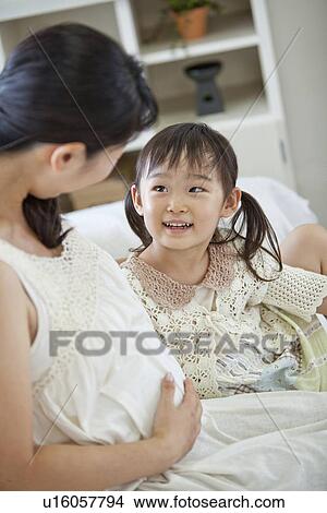 Picture - Pregnant Mother Talking to Daughter. Fotosearch