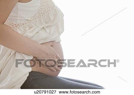 Stock Photo - Pregnant Woman Touching Her Stomach. Fotosearch