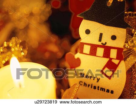 Stock Photo - Snowman ornament and candle. Fotosearch
