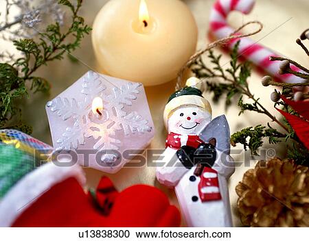 Stock Image - Snowman ornament and candles. Fotosearch