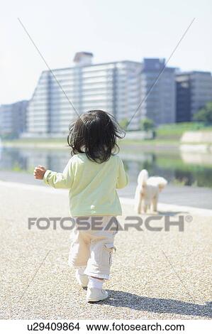 Picture - Toddler Walking After Dog. Fotosearch