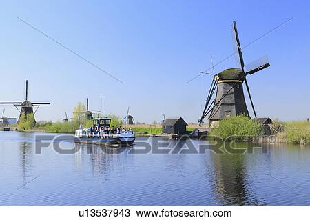 Stock Image - Tourboat Passing Windmills. Fotosearch