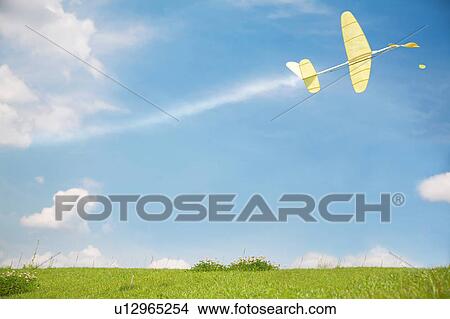 Picture - Toy Airplane Flying Over Grass. Fotosearch