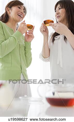 Stock Photo - Two Mid Adult Women Having Tea. Fotosearch