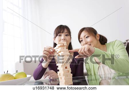 Two Women Playing Jenga View Large Photo Image Stock Photo - Two Women Playing Jenga. Fotosearch