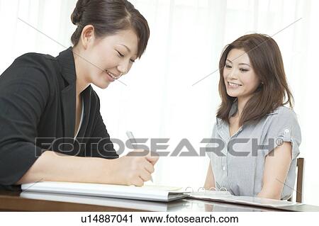 Stock Image - Woman writing a form at a Beauty Spa. Fotosearch