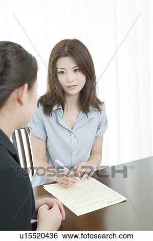 Stock Photograph - Woman writing a form at a Beauty Spa. Fotosearch