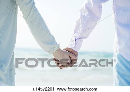 Young Couple Holding Hands at Beach View Large Photo Image Stock Image - Young Couple Holding Hands at Beach. Fotosearch