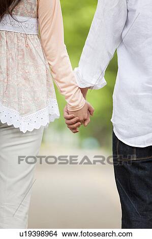Picture - Young couple holding hands, close-up. Fotosearch