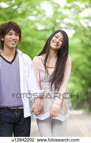 Stock Image - Young couple holding hands. Fotosearch