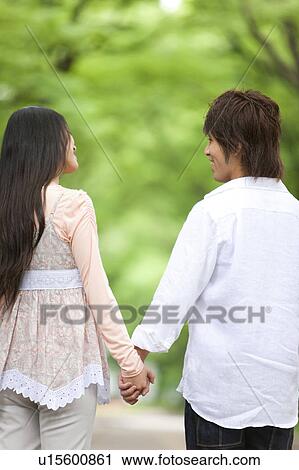 Stock Image - Young couple holding hands. Fotosearch