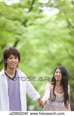 Stock Image - Young couple holding hands. Fotosearch
