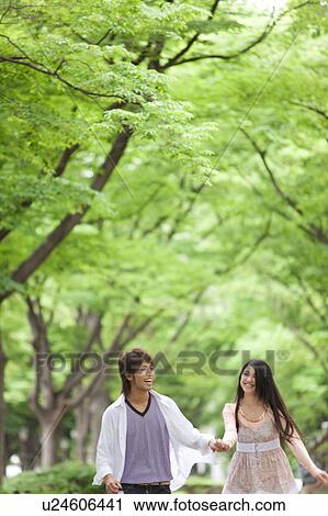 Stock Image - Young couple holding hands. Fotosearch