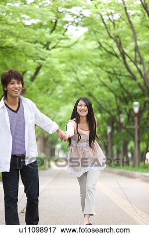 Stock Photo - Young couple holding hands. Fotosearch