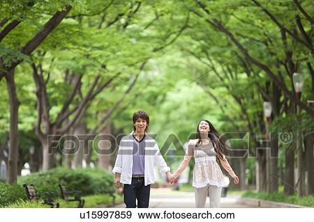 Stock Photo - Young couple holding hands. Fotosearch