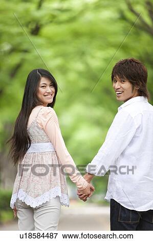 Stock Photo - Young couple holding hands. Fotosearch