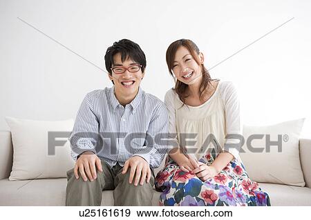Young couple standing side by side and smiling View Large Photo Image Stock Photo - Young couple standing side by side and smiling. Fotosearch