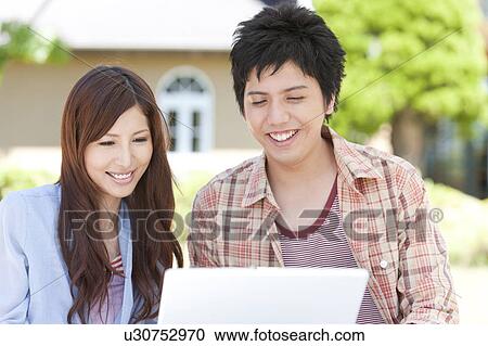 Stock Image - Young Couple Using Laptop. Fotosearch